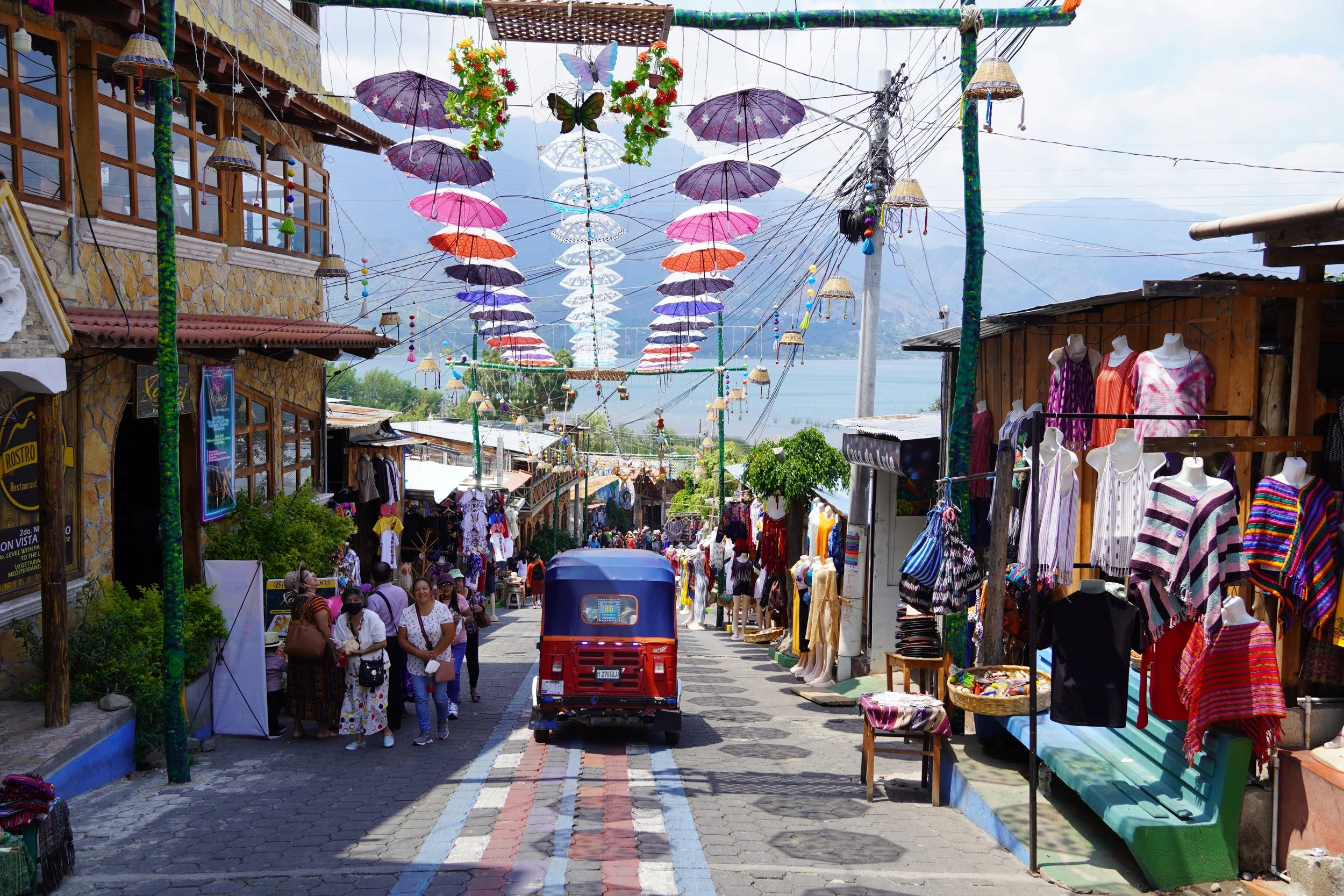 Lake Atitlan small street with vibrant buildings and umbrellas hanging in the air