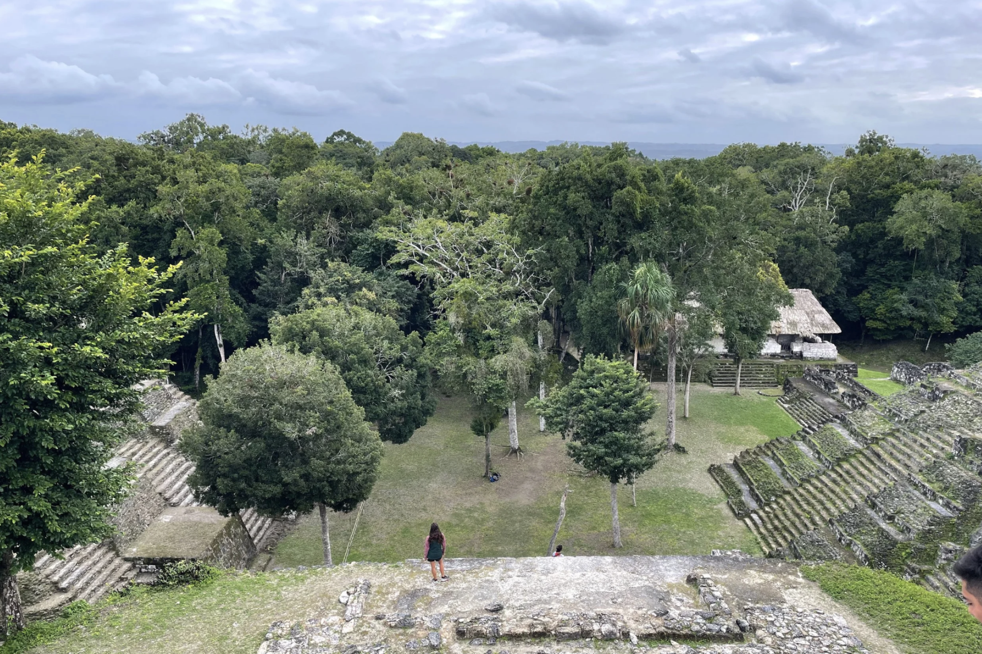 A girl is standing and looking out at the beautiful Mayan ruins in the Petén region of Guatemala.