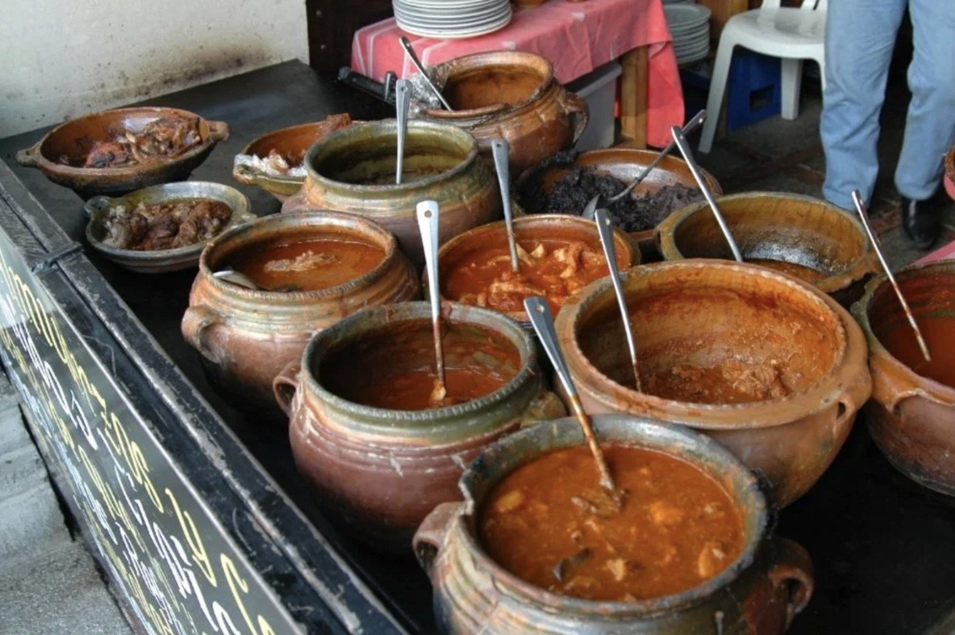 A variety of pots with spoons has different soups and Guatemalan street food