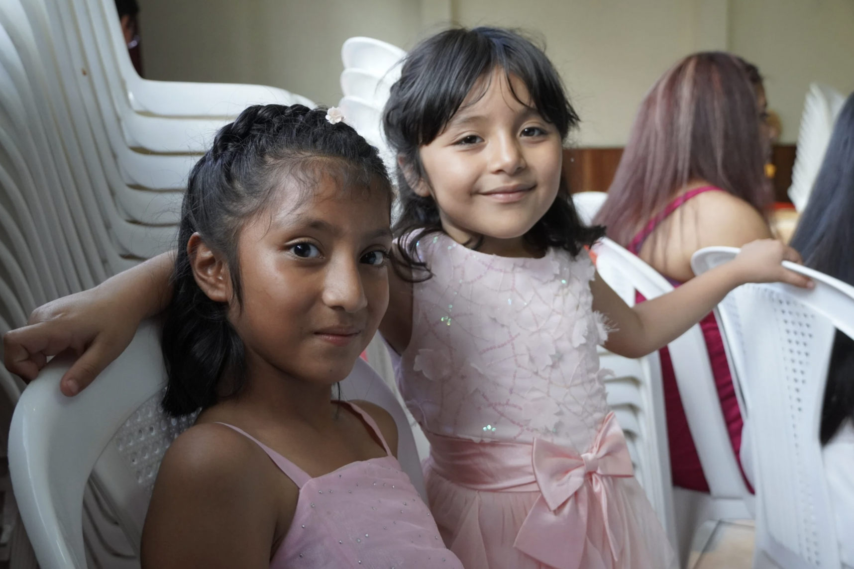 Two girls in pink dresses smile at the camera at the princess castle opening event for a girls orphanage in Guatemala. Two girls in pink dresses smile at the camera at the princess castle opening event for a girls orphanage in Guatemala.