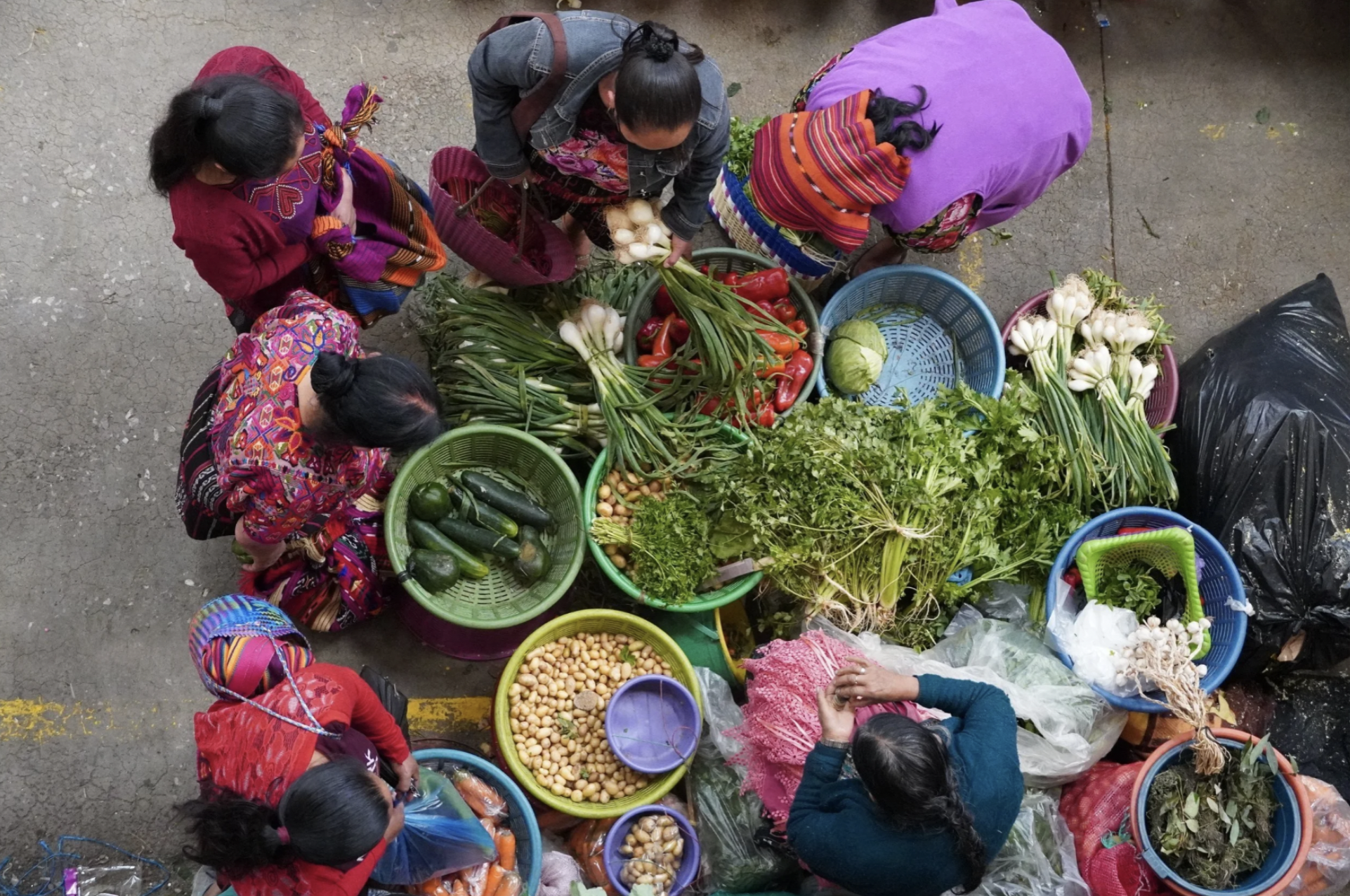 A group of women stand over a veggie market in Guatemala. the Land of Eternal Spring.