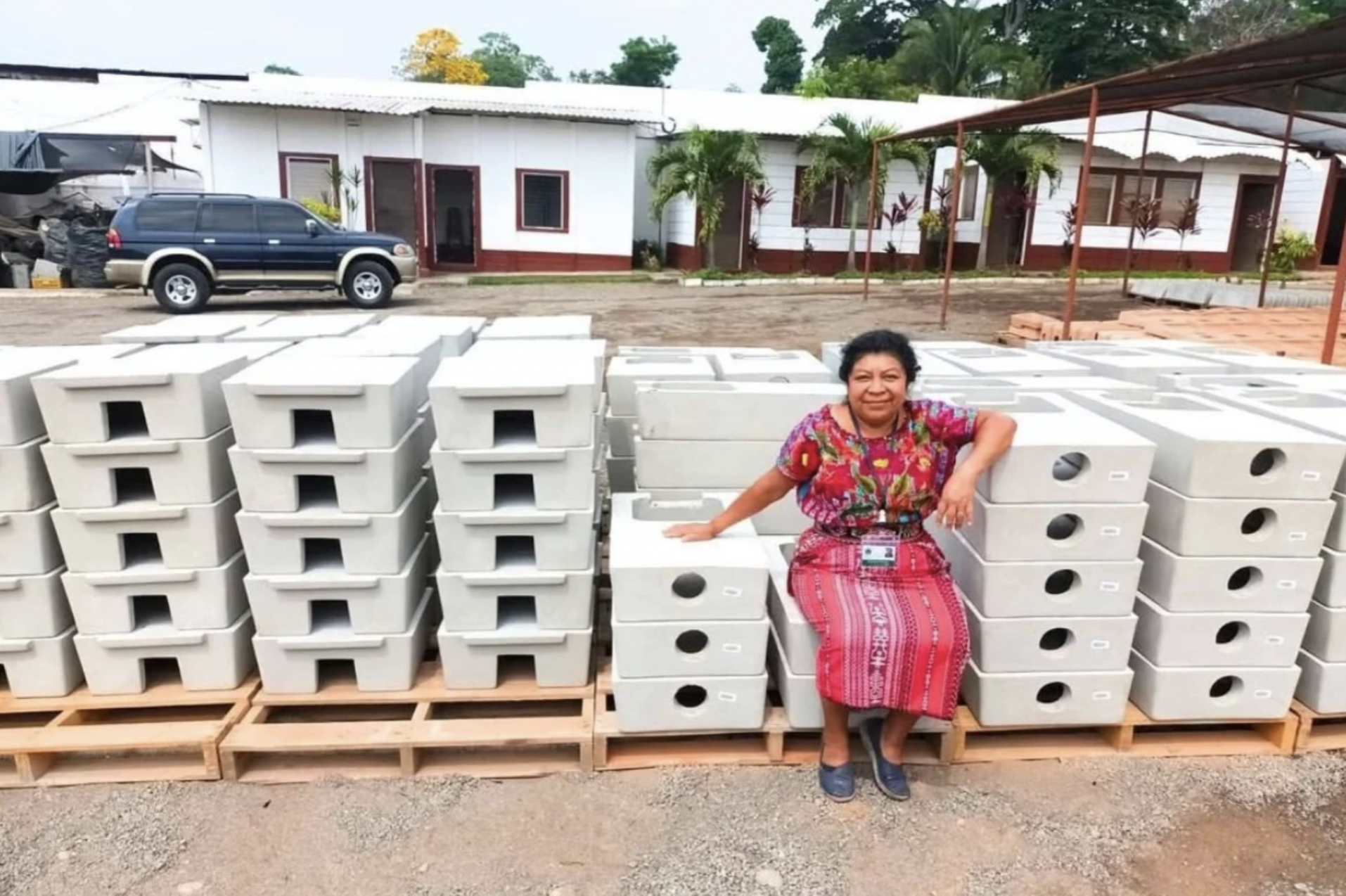 A woman in traditional clothing is sitting on cookstoves from Tui'k Ruch'lew, an organization you can donate to on Giving Tuesday
