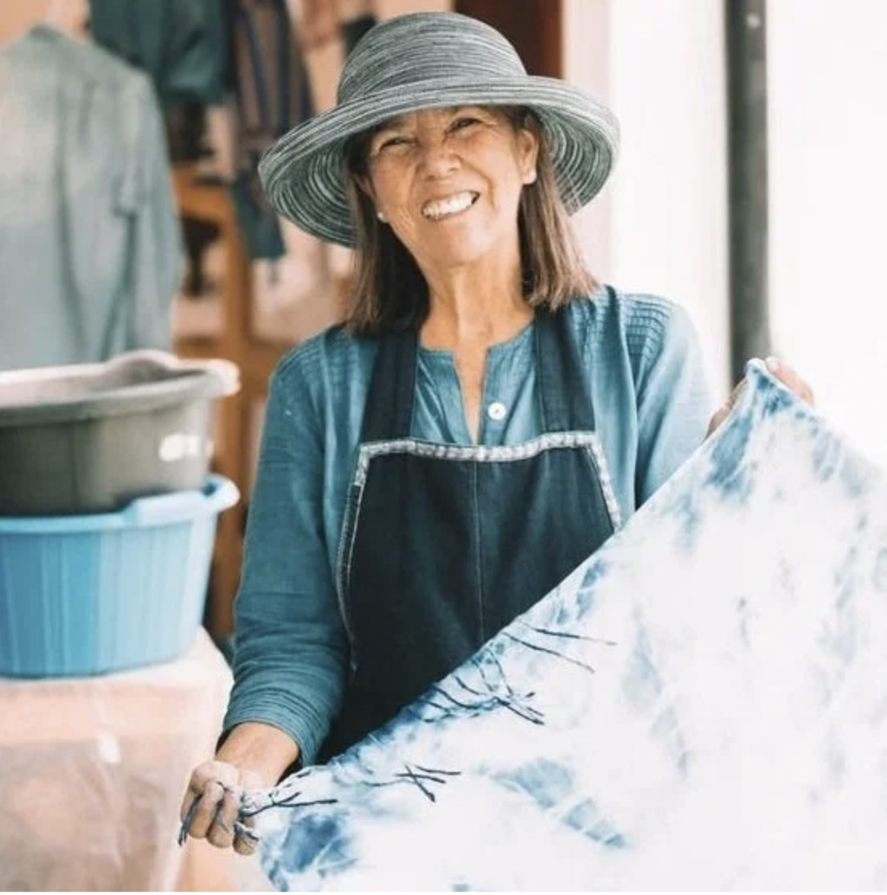 Olga Reiche is holding up a piece of natural indigo dyed fabric at her workshop and boutique store in Antigua, Guatemala.