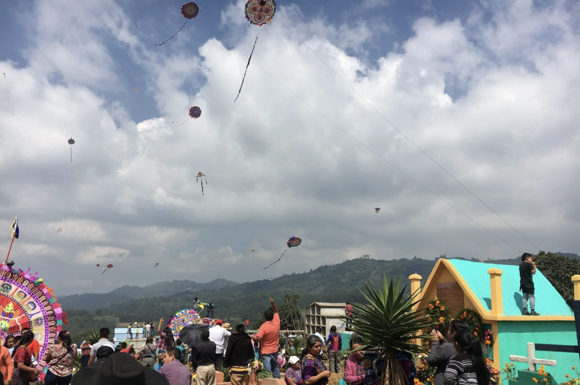 People watch as the smaller kites are flown in the sky above the cemetery in Sumpango during the kite festival