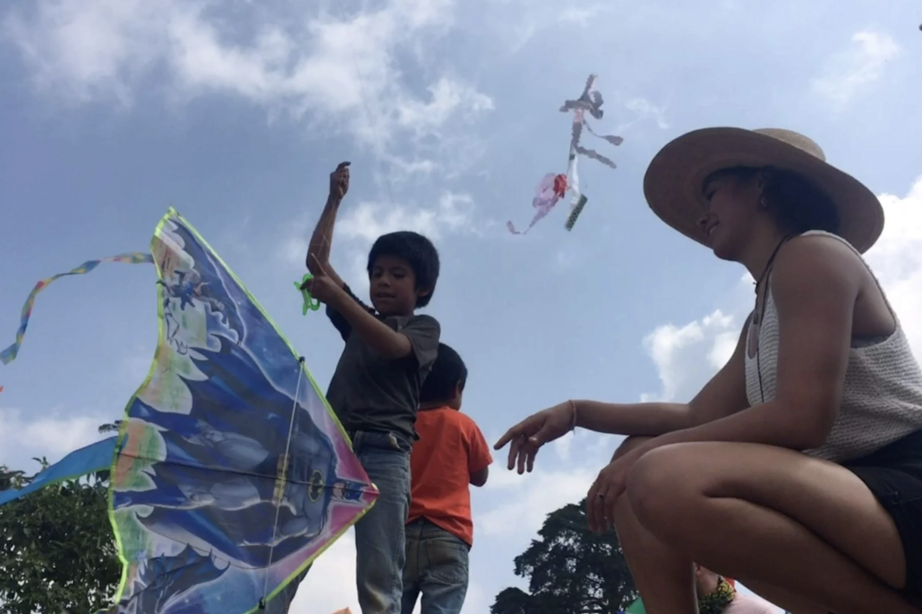 A child and a woman are about to launch a kite into the sky at the Day of the Dead Kite Festival in Sumpango, Guatemala.
