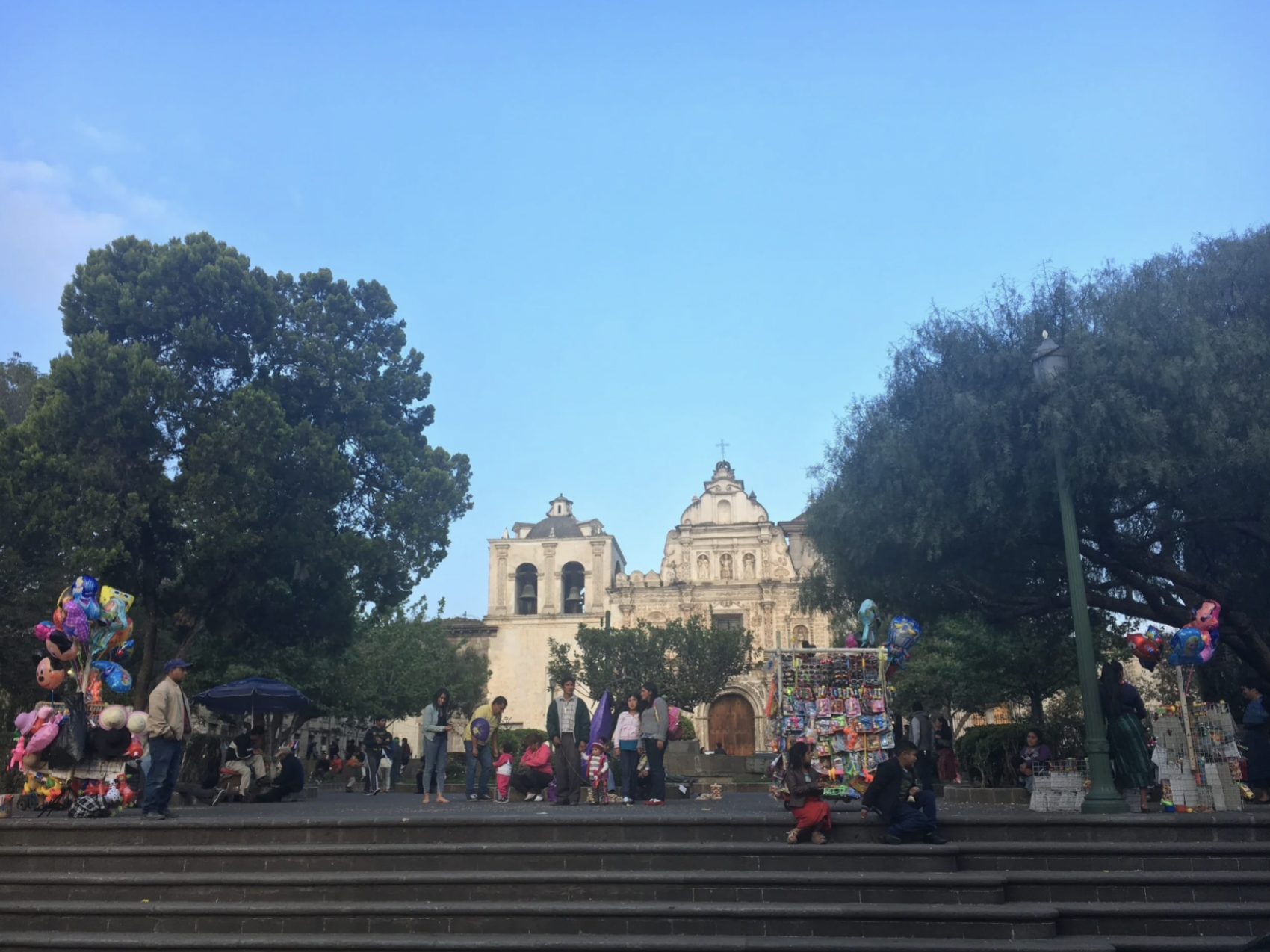 People are gathered around the steps outside of a church in Xela, Guatemala.