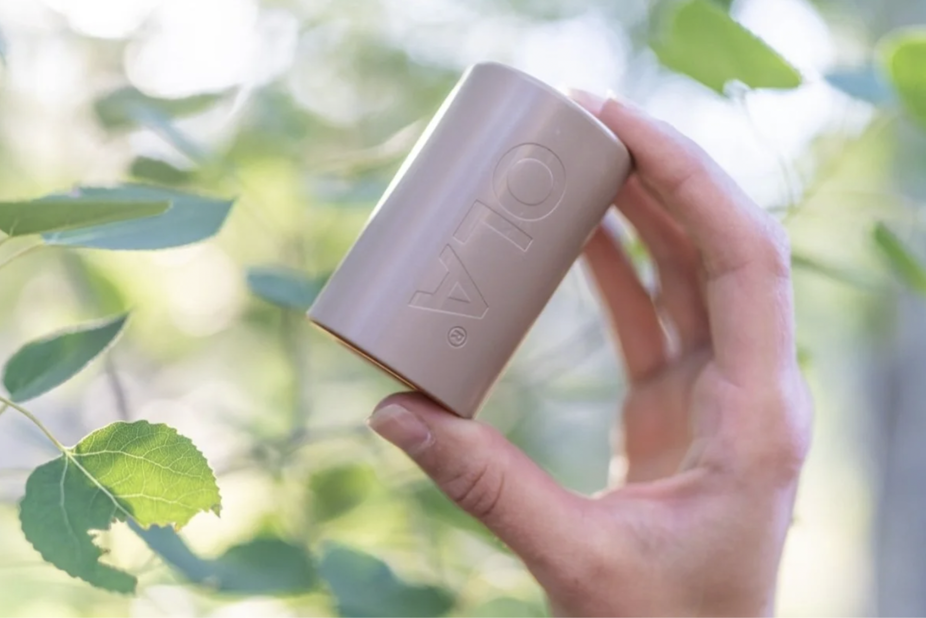 A person is holding up the Ola water filter, an organization you can donate to on Giving Tuesday