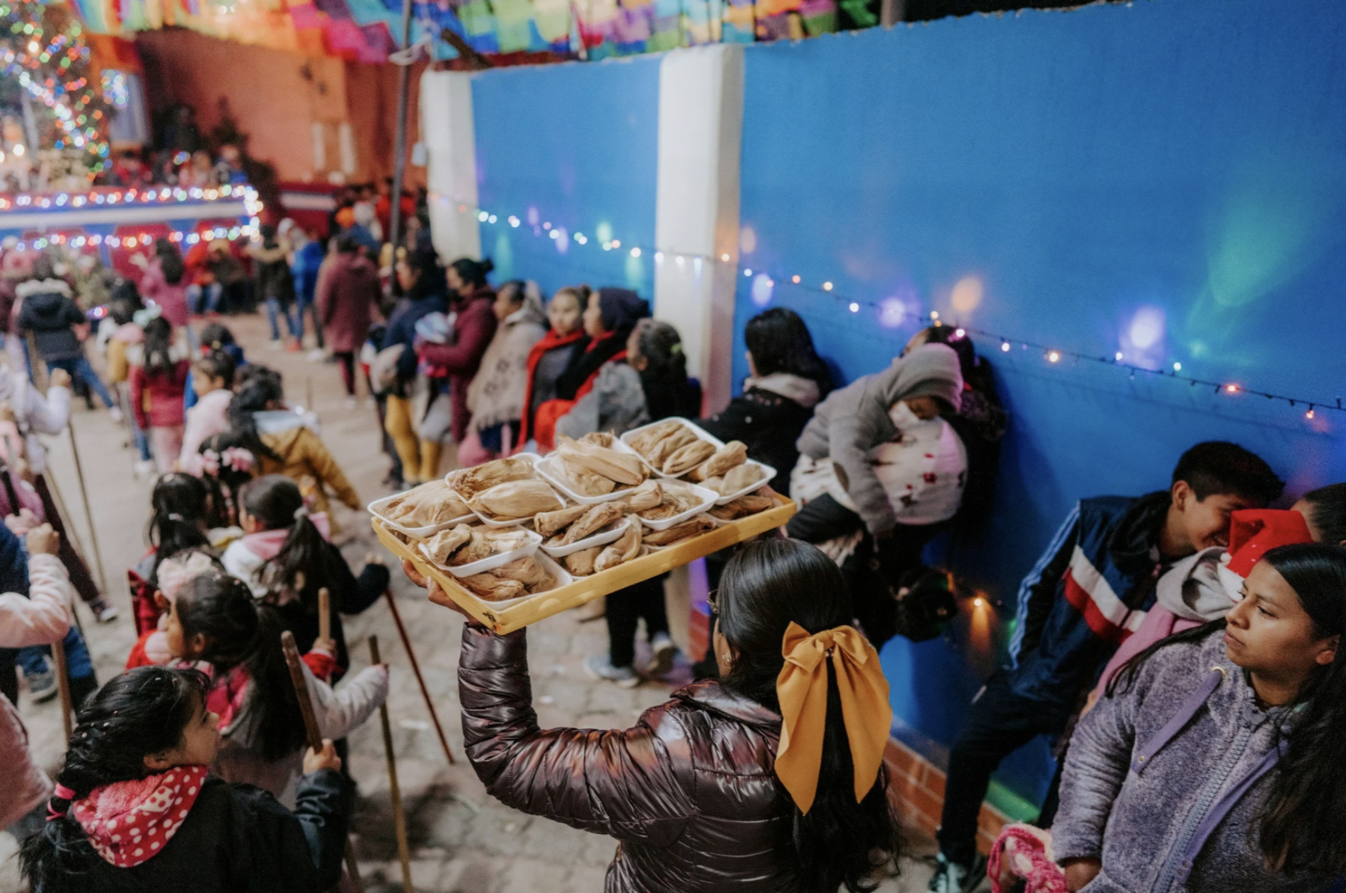 A woman carries a tray of food during las posadas Christmas celebrations during the holidays in Guatemala