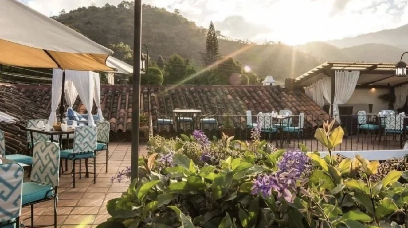 The outdoor seating area at one of the best boutique hotels Antigua with flowers, chairs, tables, and views