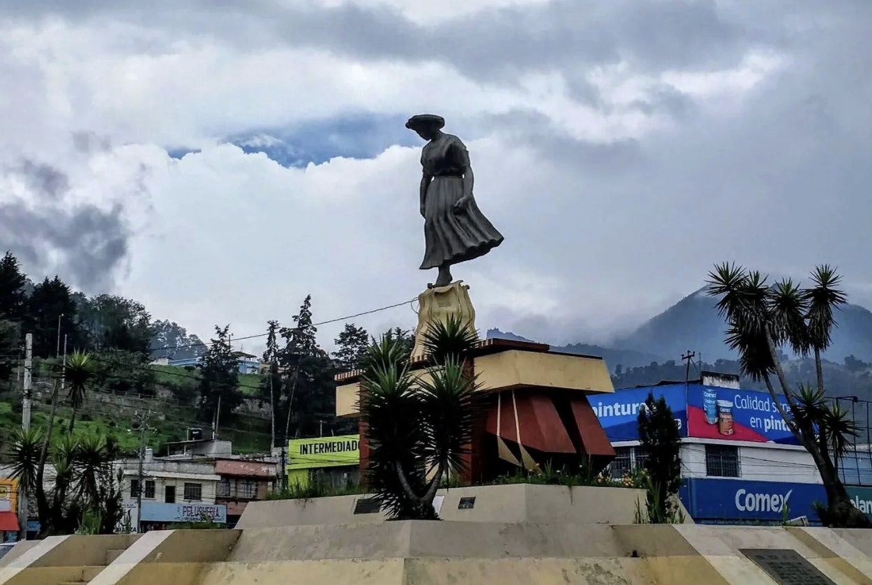 The busy town traffic circle with a statue in the middle of Xela, Guatemala