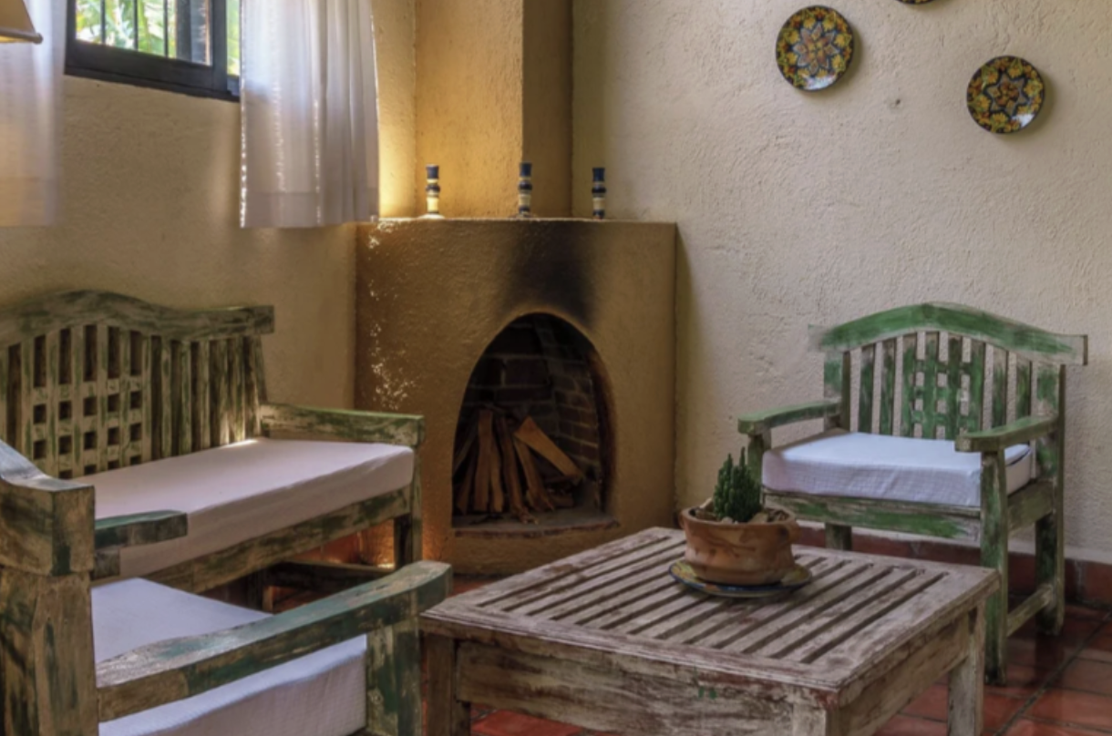 The lobby area of a hotel with a fireplace and chairs at an eco-friendly hotel in Lake Atitlan 