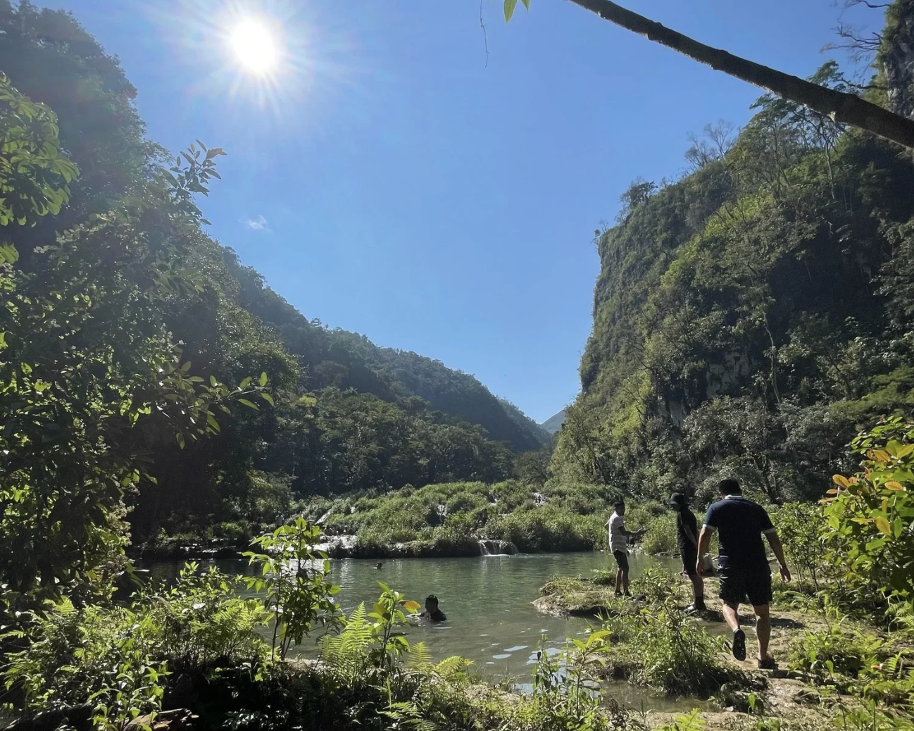 People walking along with turquoise-colored waters in Guatemala's remote Semuc Champey