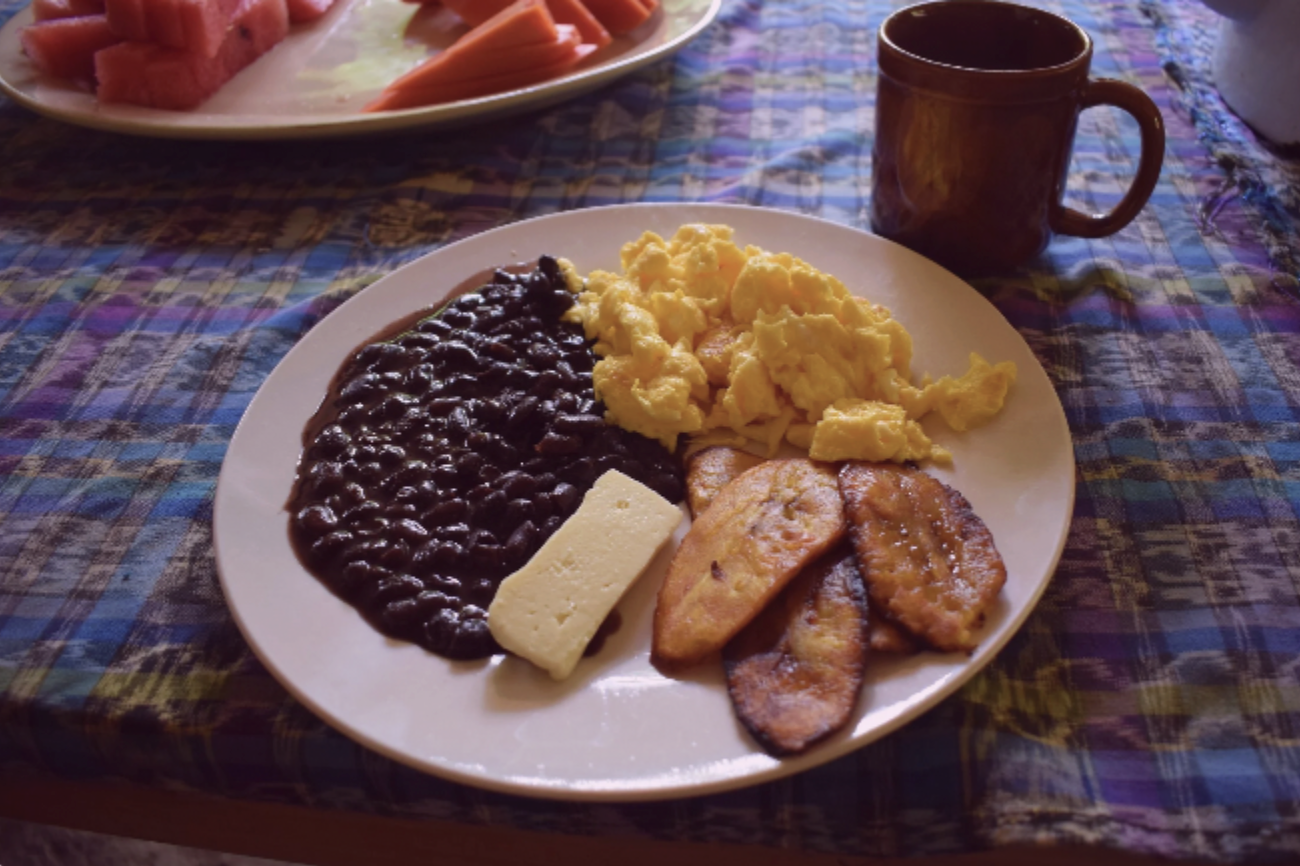 A hearty, local breakfast plate with cheese, eggs, and beans at an eco-friendly hostel in Semuc Champey
