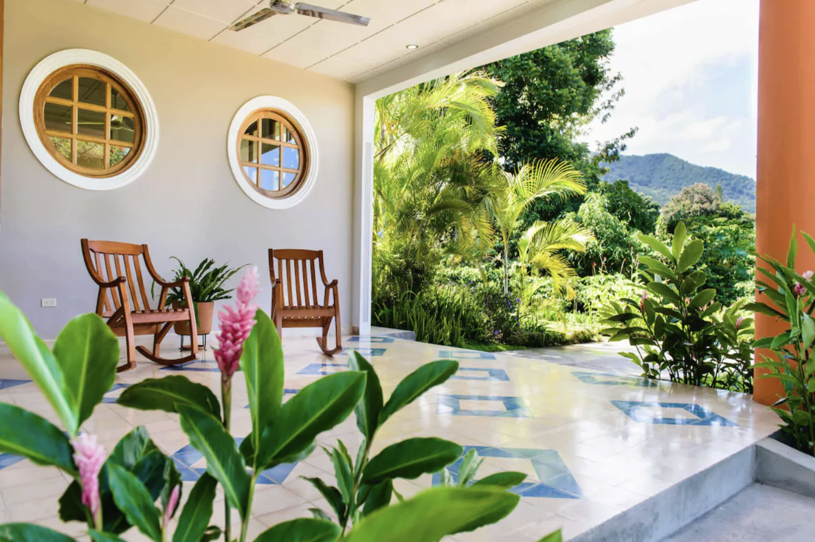 Two wooden rocking chairs are on the outside patio of a hotel in Nicaragua