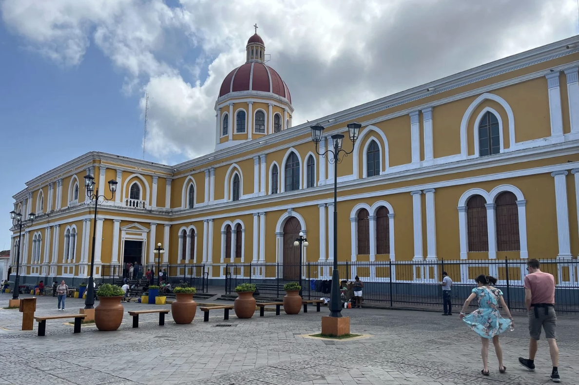 The outside of a large yellow cathedral in Nicaragua