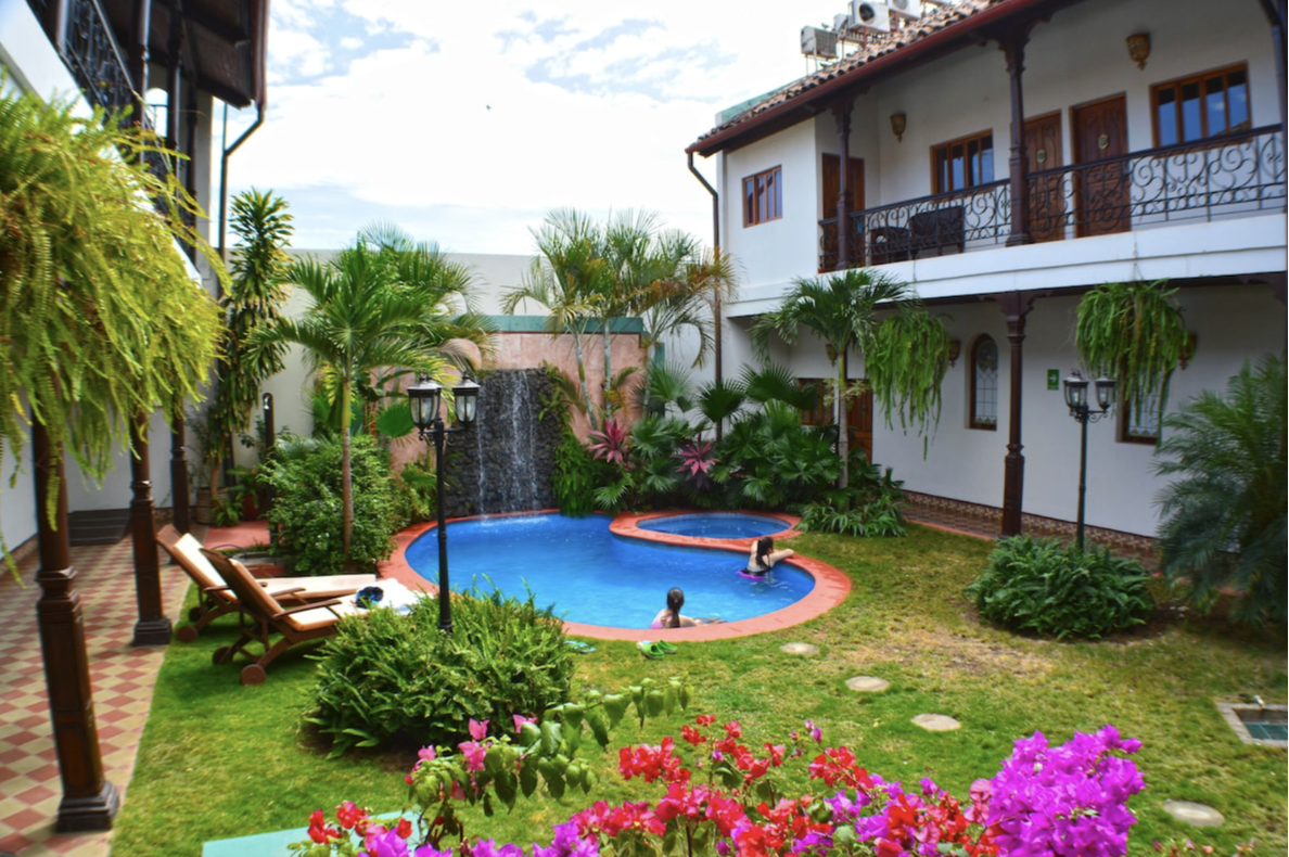 The outdoor area of one of the best hotels in Nicaragua with a courtyard, green spaces, and a pool