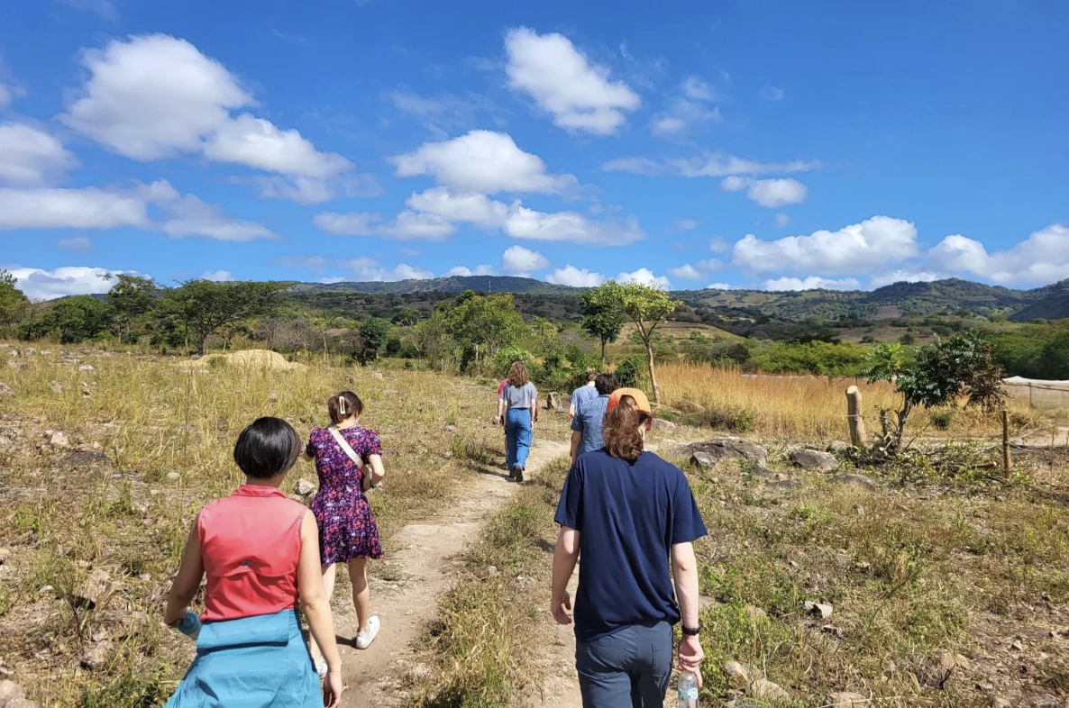 A group of people are walking on a path outside on a sunny day in Nicaragua