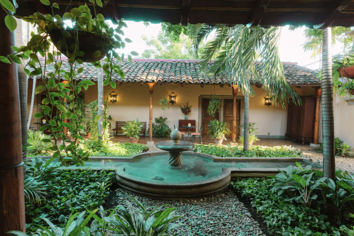 The outdoor courtyard of one of the best hotels in Nicaragua with a fountain and lush green area