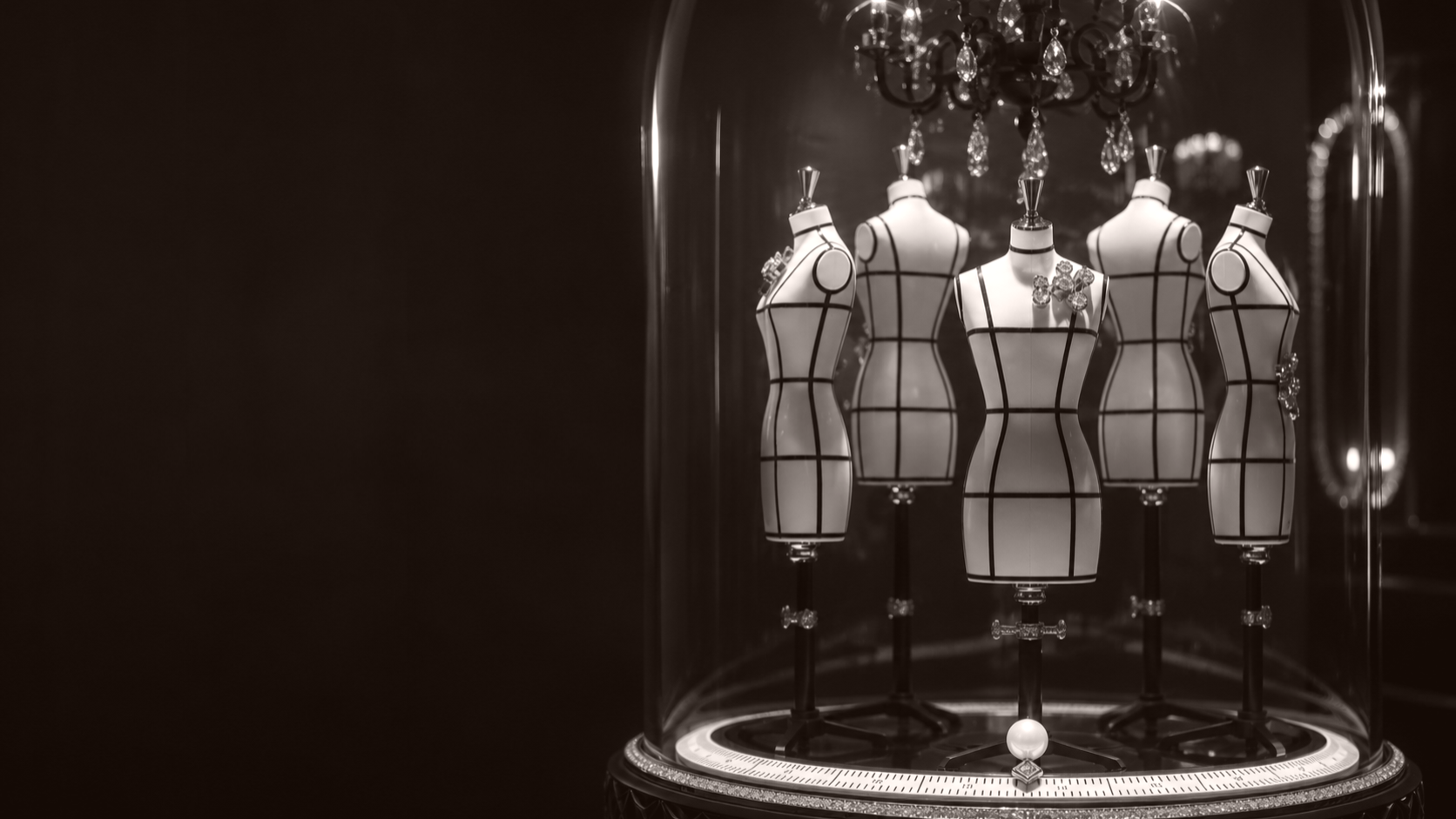 Haute couture mannequins displayed beneath a glass dome, symbolising tailored strategic perspectives in luxury