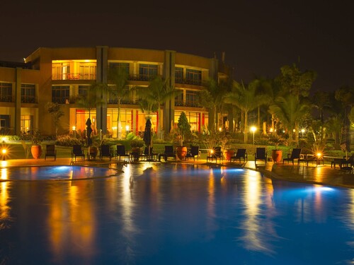 Protea Hotel Entebbe illuminated at night beside its swimming pool