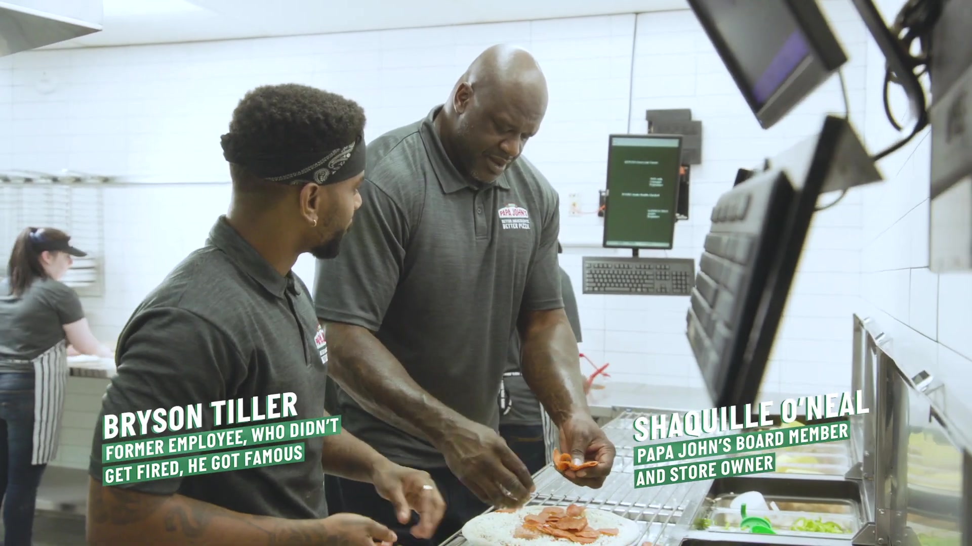Bryson Tiller and Shaquille O'Neal making pizza in a Papa John's kitchen
