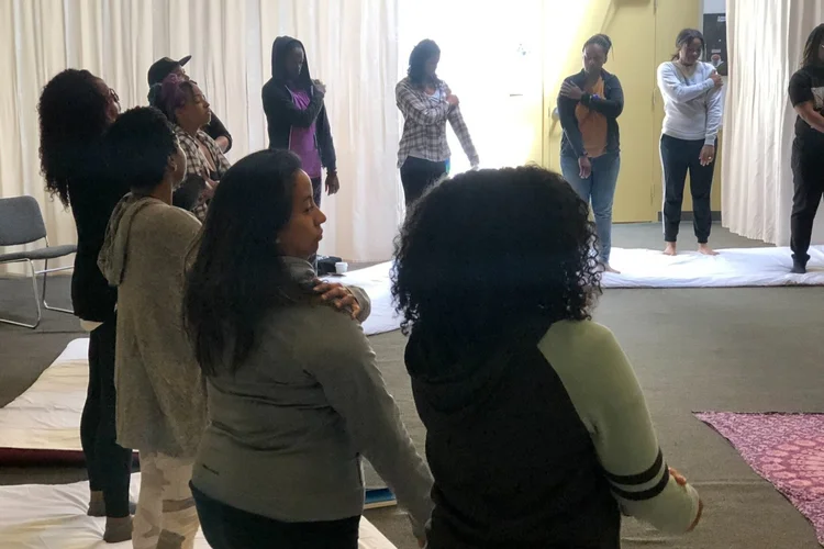 Kiara leads a large group of women through healing practices