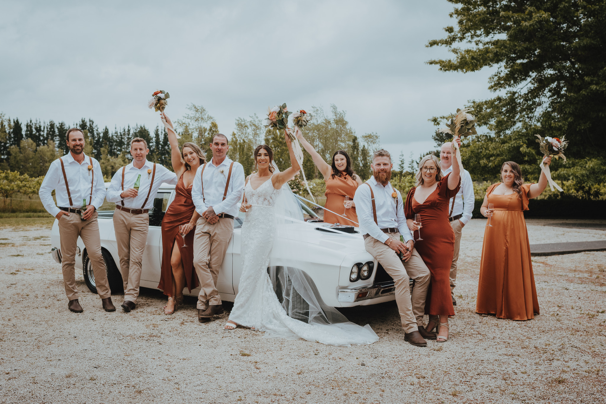bridal party posing with car bridal party posing with car