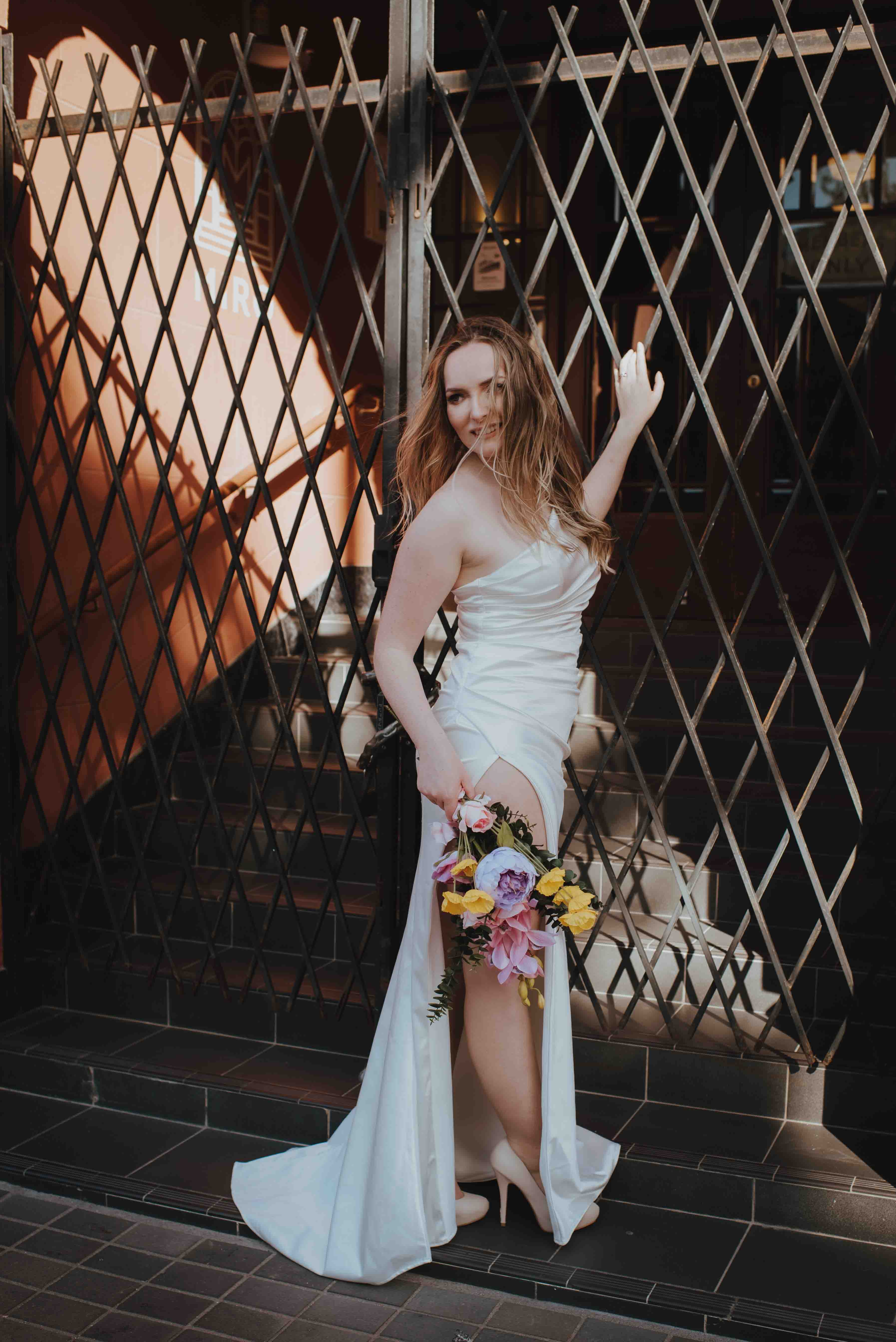 bride leaning off of grated door