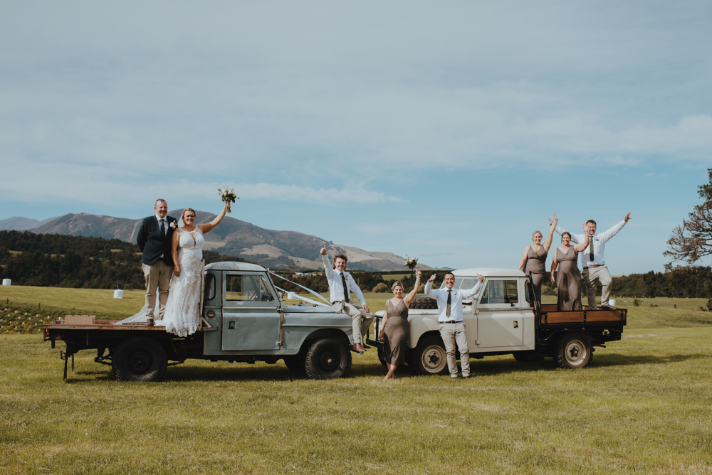 bridal party on top of landrovers for country wedding