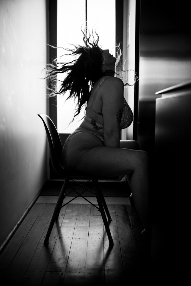 woman flipping her hair sitting on a chair