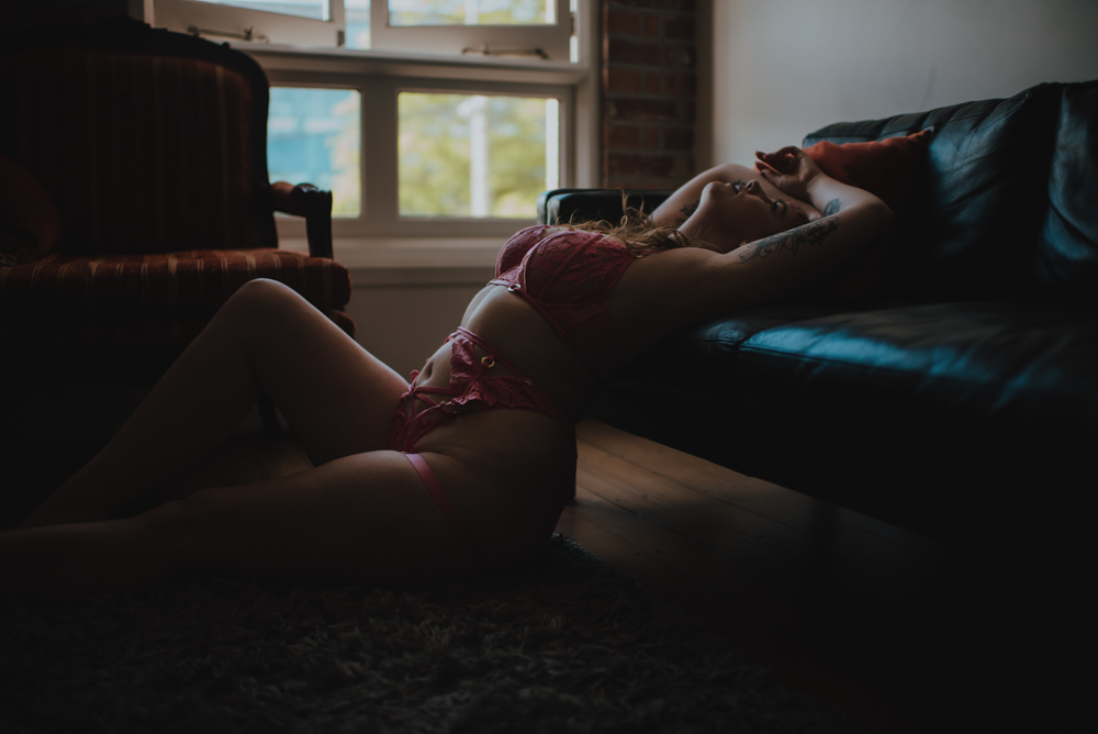 woman leaning her back against a sofa while sitting on the floor