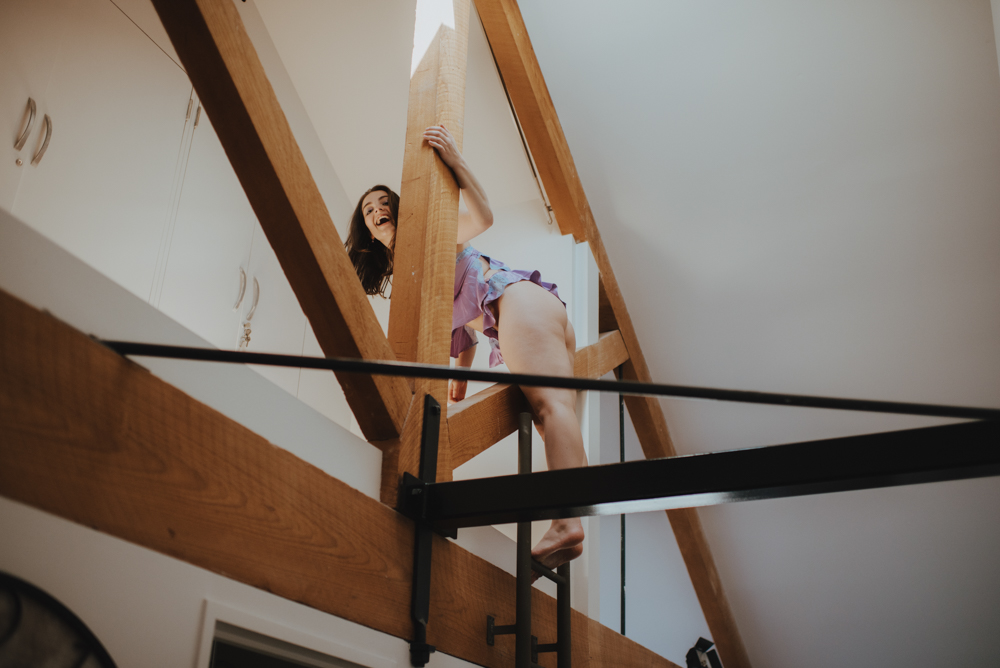 woman laughing while climbing a ladder woman laughing while climbing a ladder