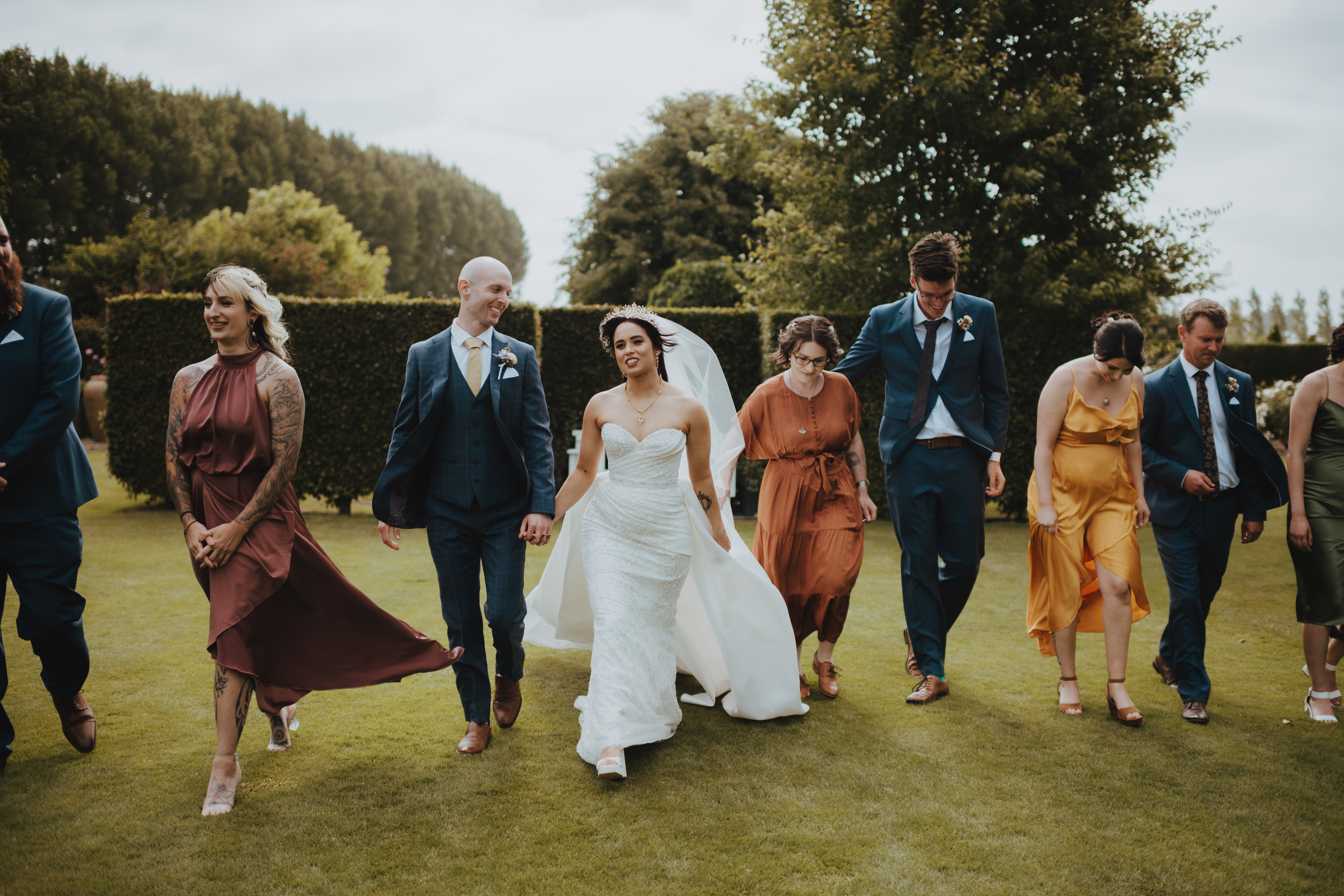 bridal party walking through the garden together bridal party walking through the garden together