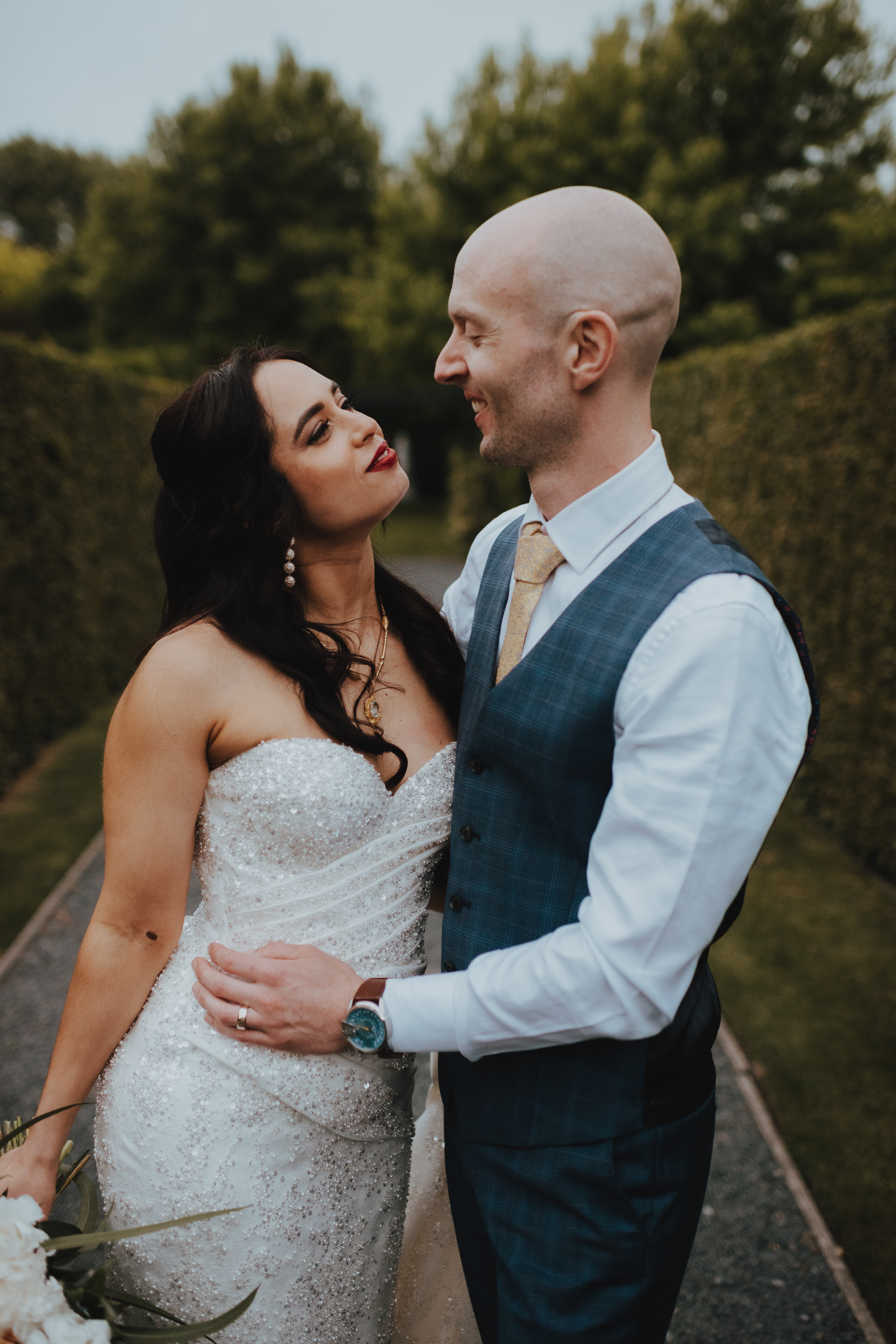newlyweds in front of hedge for portraits newlyweds in front of hedge for portraits