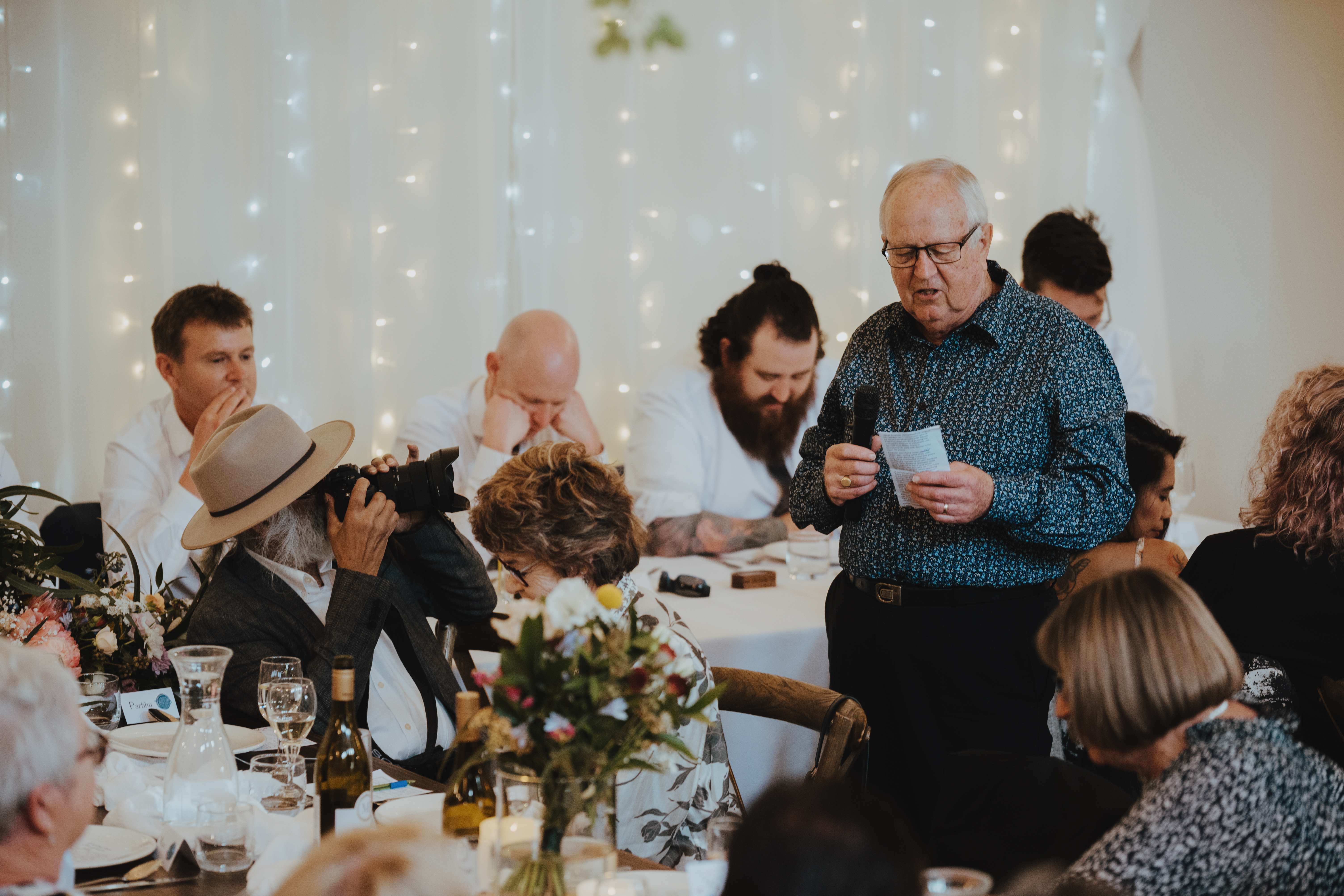 grooms father making his speech while the brides father takes photos grooms father making his speech while the brides father takes photos