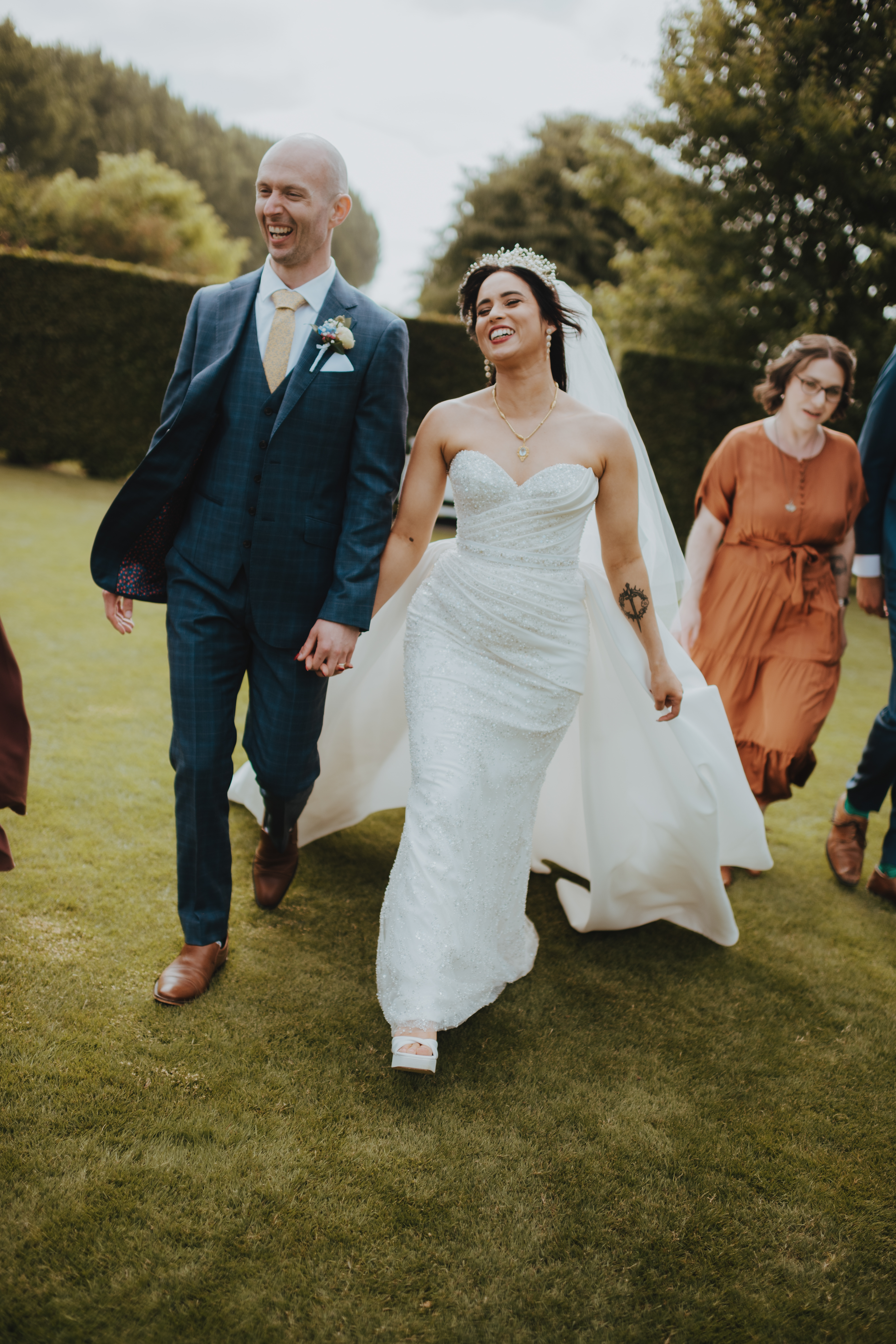 bride and groom laughing walking through the garden bride and groom laughing walking through the garden