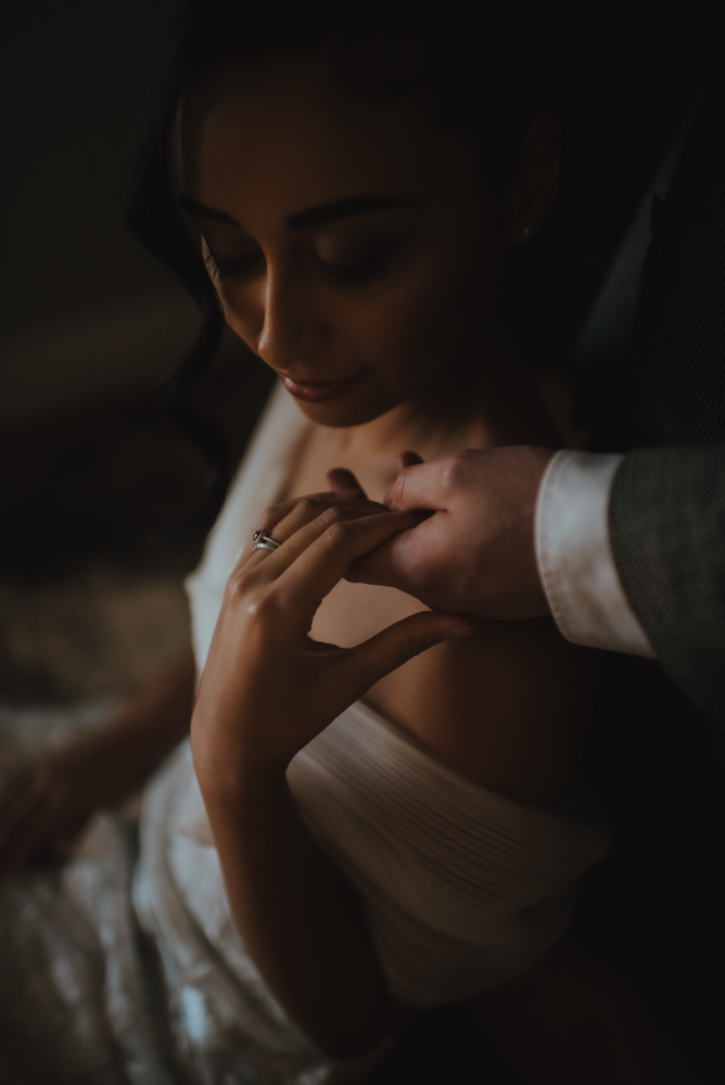 dark and moody bridal and ring portrait with grooms hand dark and moody bridal and ring portrait with grooms hand