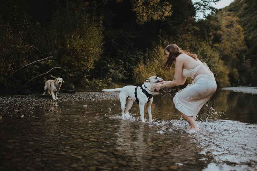 woman with dogs at river bed