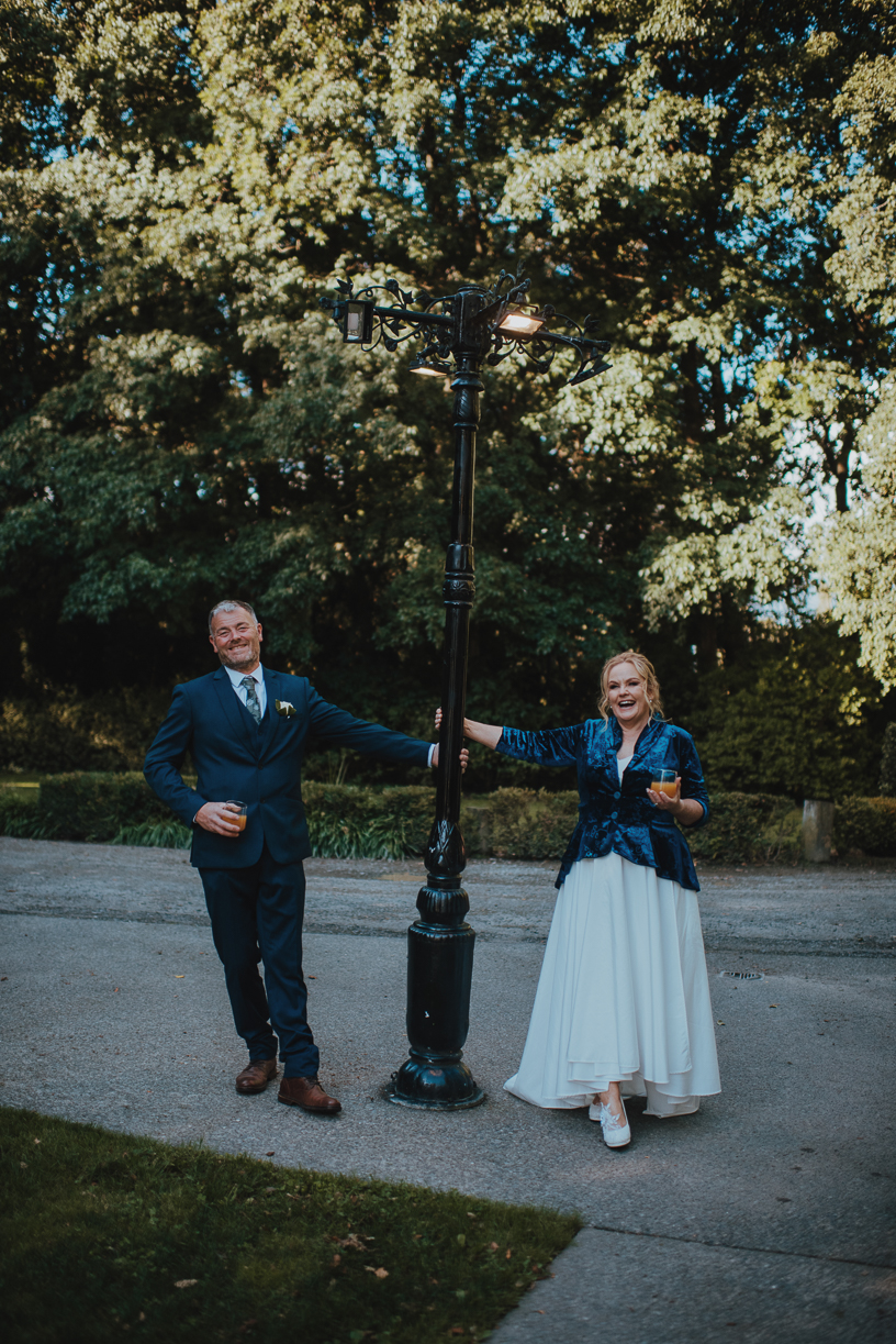 newlyweds swinging off of a lamp post