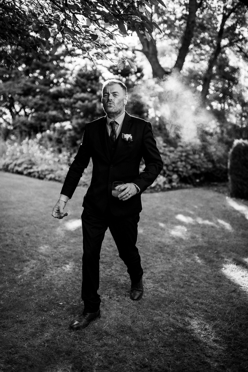 black and white version of image of a groom smoking a cigar black and white version of image of a groom smoking a cigar