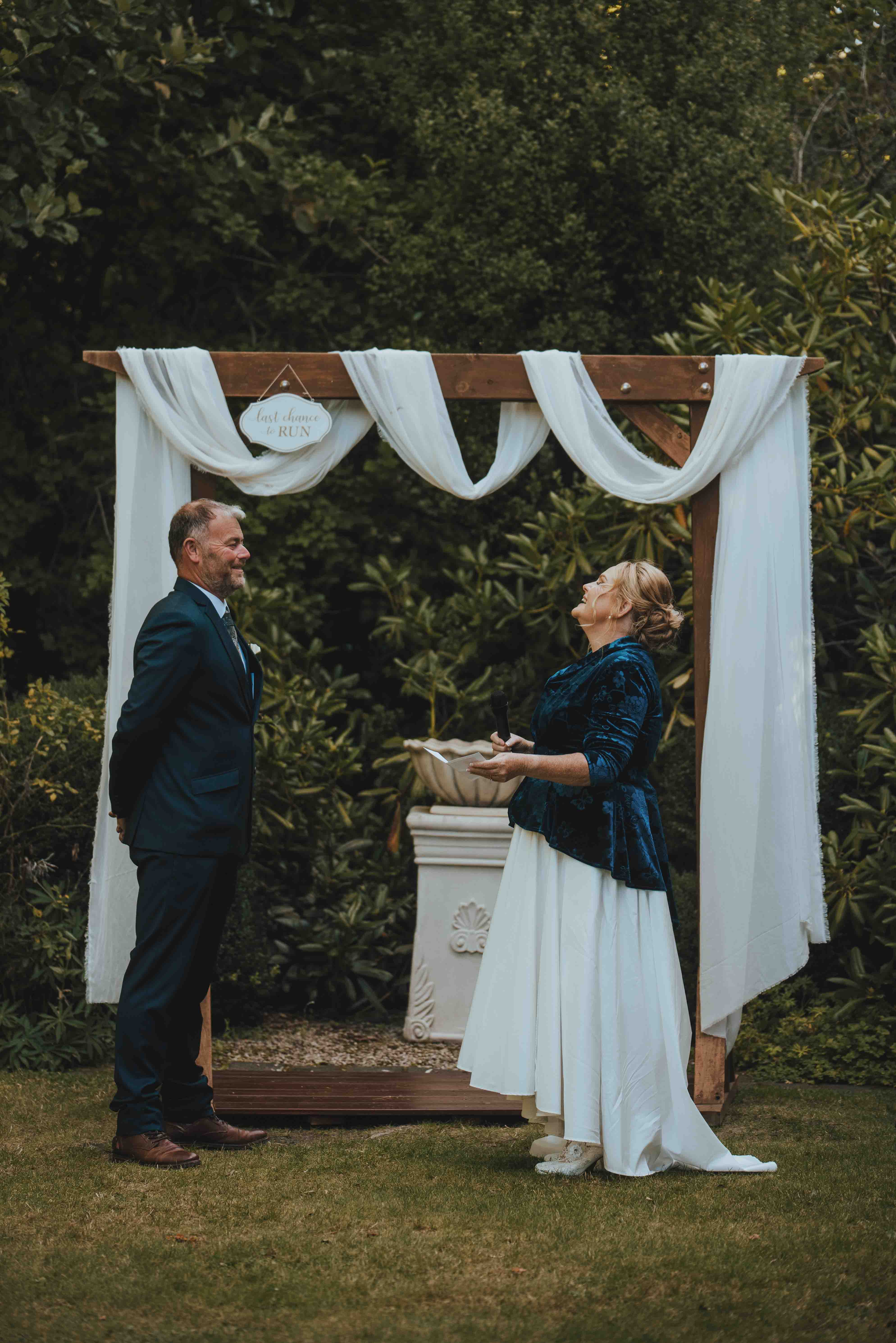 bride laughing at a joke made by the groom during vow