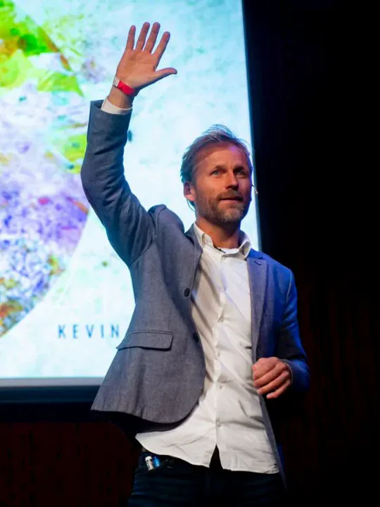 Kevin Frøystad vinker til publikum fra scenen på Litteraturhuset