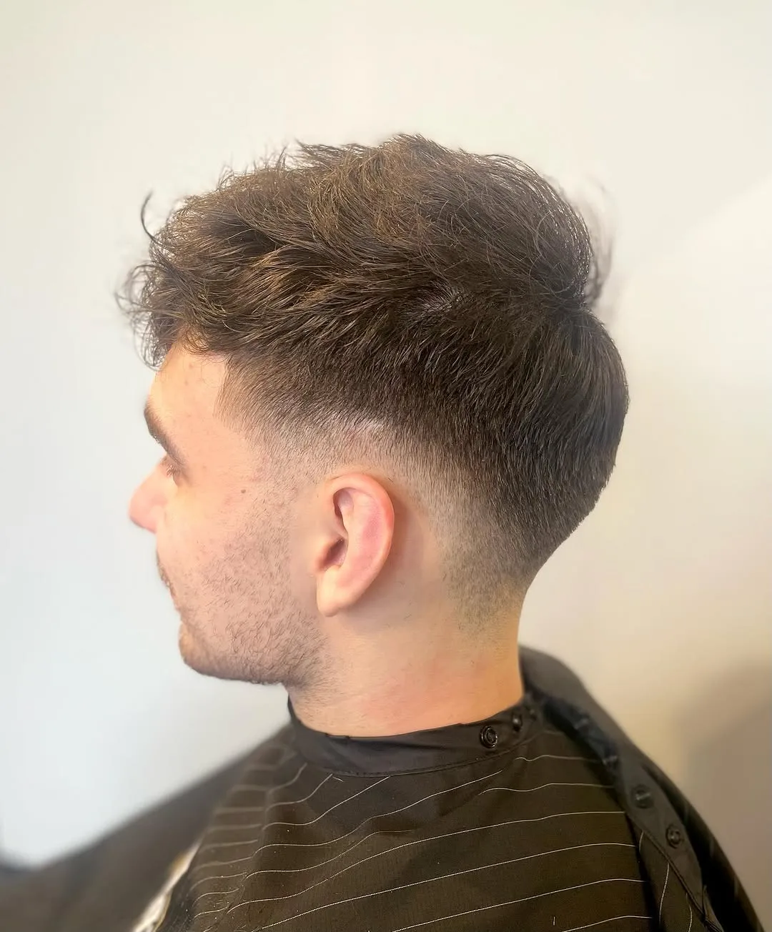 Textured men’s haircut with soft fade by Cuts By Gage