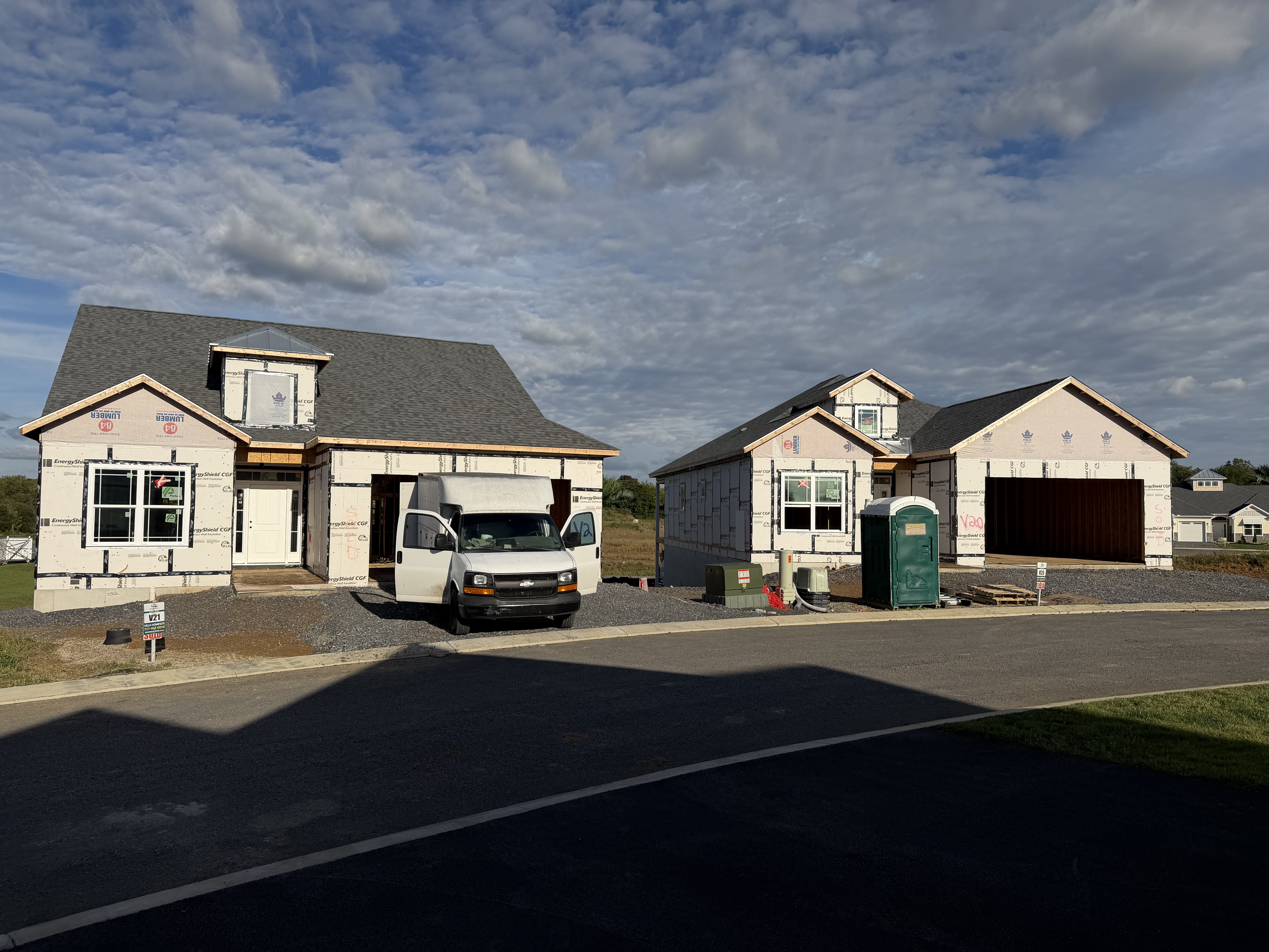 BK Electric work van parked in front of two new homes under construction