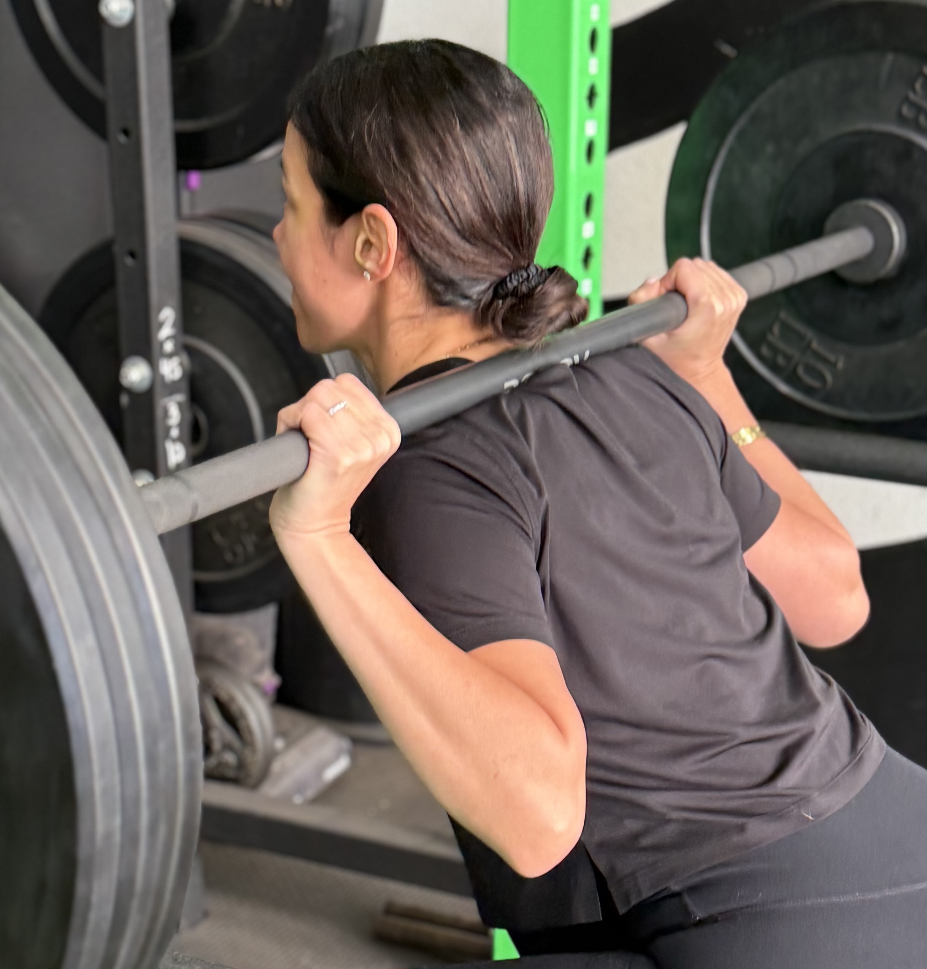 fit woman doing barbell back squats