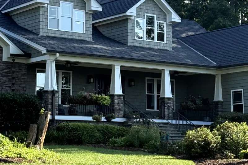 Architectural asphalt shingle roof over two gabled dormers and a craftsman front porch