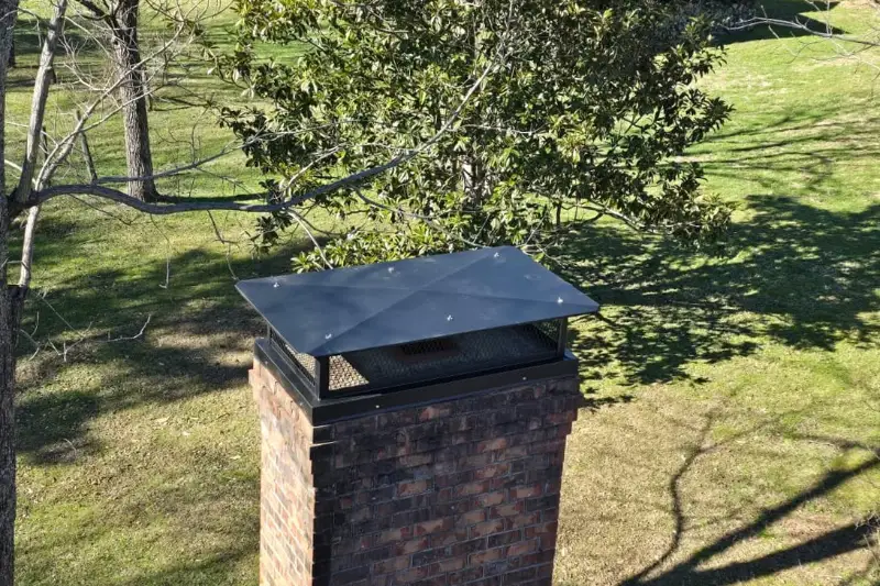 Custom fabricated metal chimney cap on a brick chimney