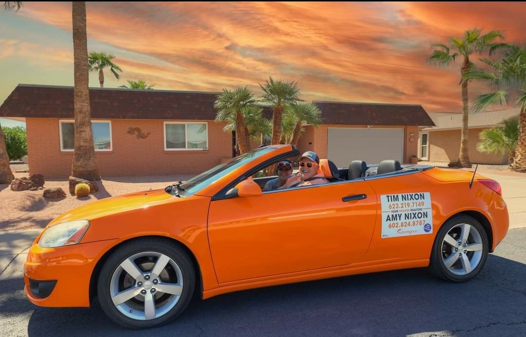 The Nixon Group's orange convertible in front of a Sun City home