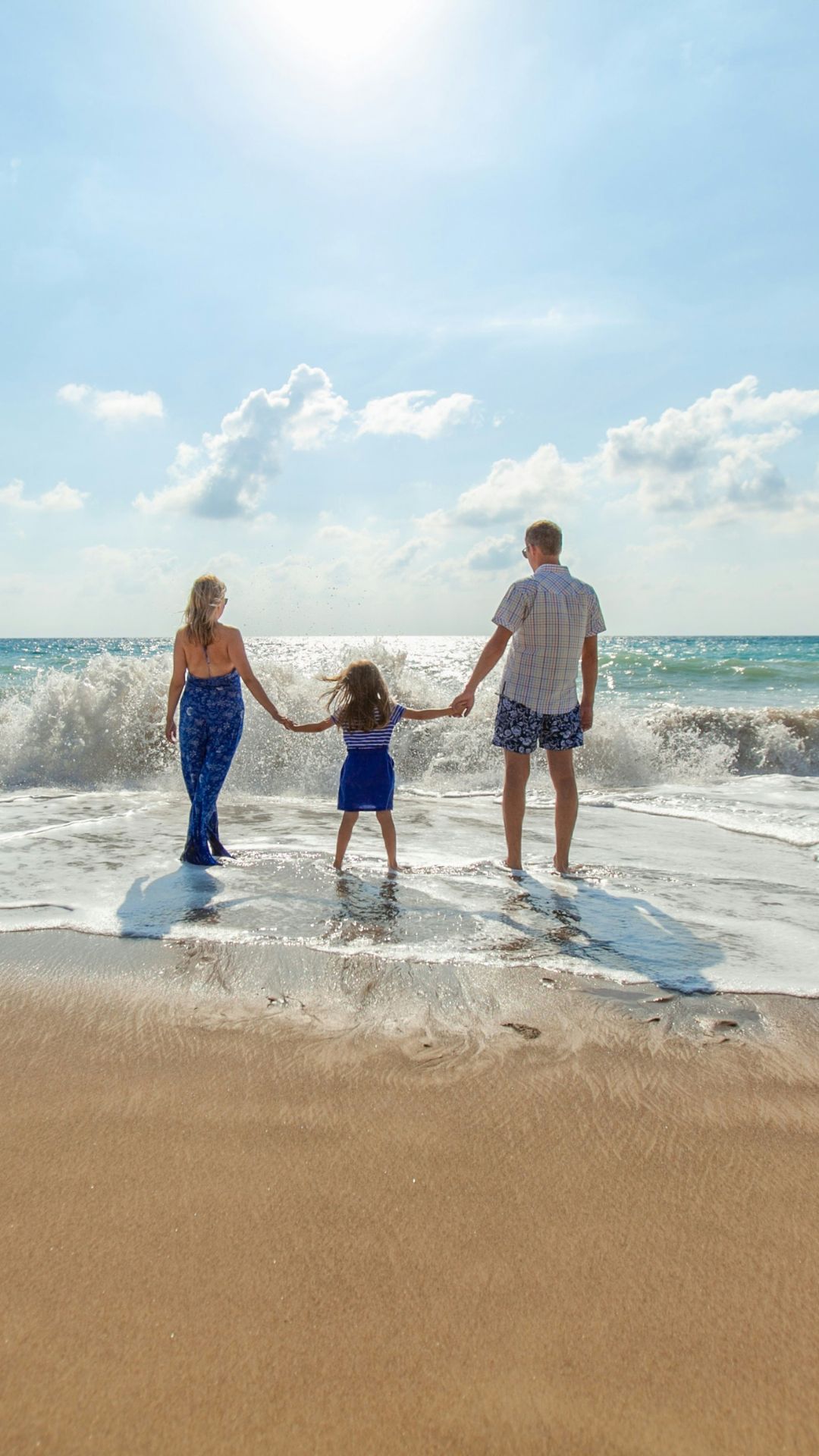 family holding hands staring at the beach