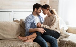 Couple sitting close together on a couch, intimacy restored